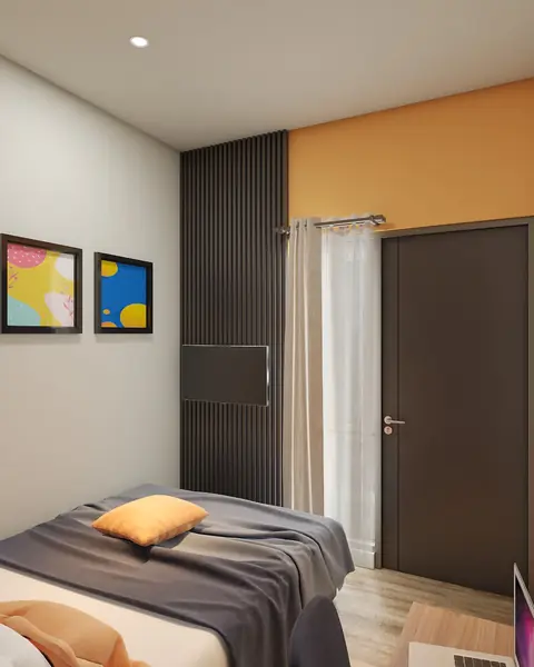 Sudut kamar dengan dinding panel hitam, dinding oranye, dan bantal oranye